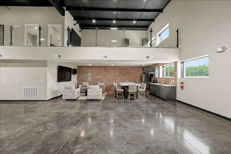 Eagle Lux garage condo finished out with a glass-railed mezzanine and brick-walled lounge – Maize, KS