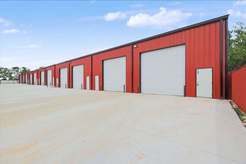 Row of white overhead doors on the red steel Eagle Lux garage condo building – Maize, KS